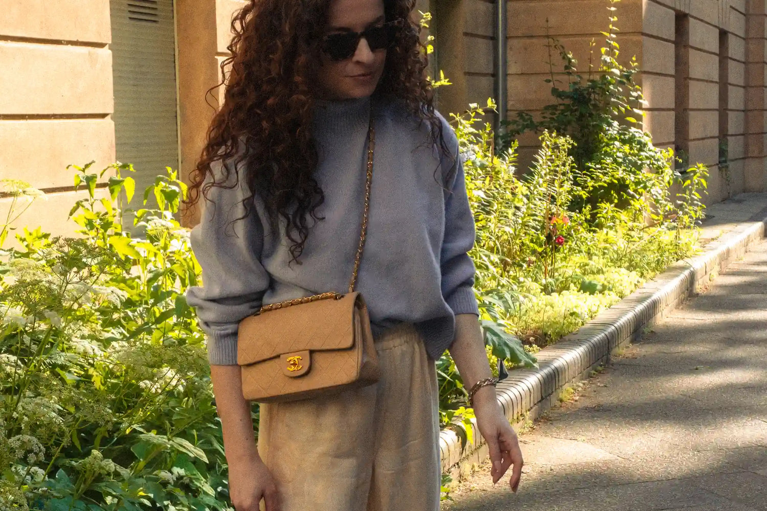 woman wearing a beige chanel small classic flap cross-body