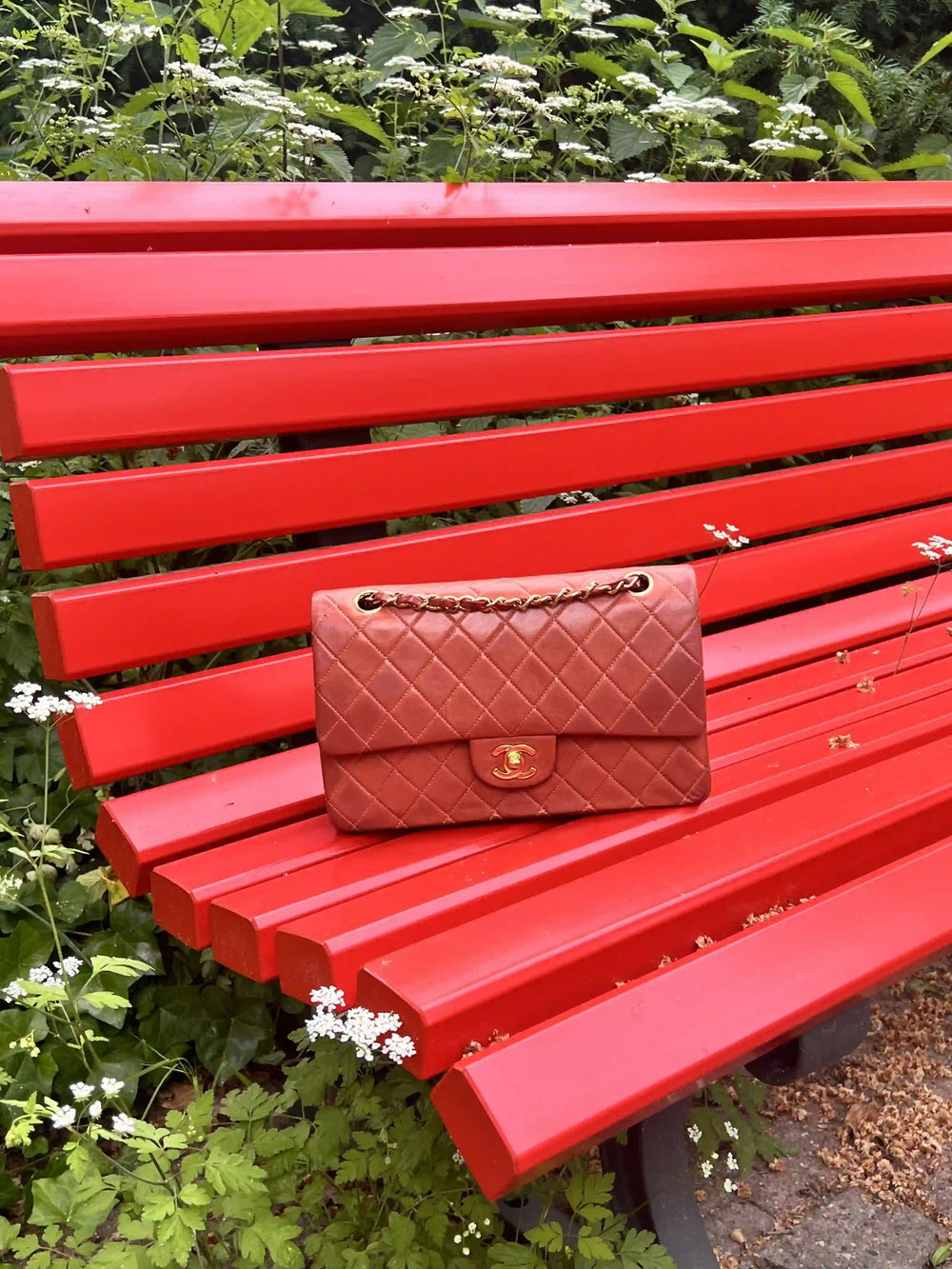 brique red chanel medium classic flap on a red bench