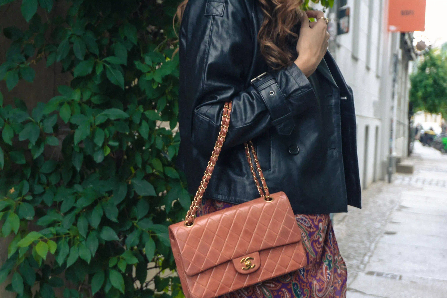 woman wearing a brique red chanel medium classic flap over her arm